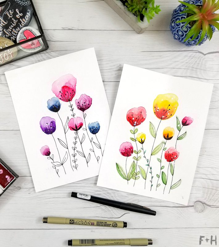 watercolor flower paintings on white desktop with art supplies