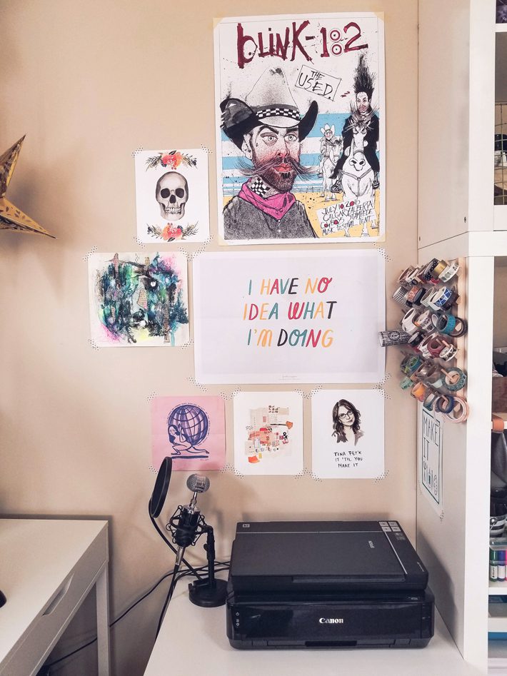 wall with art posters above printer