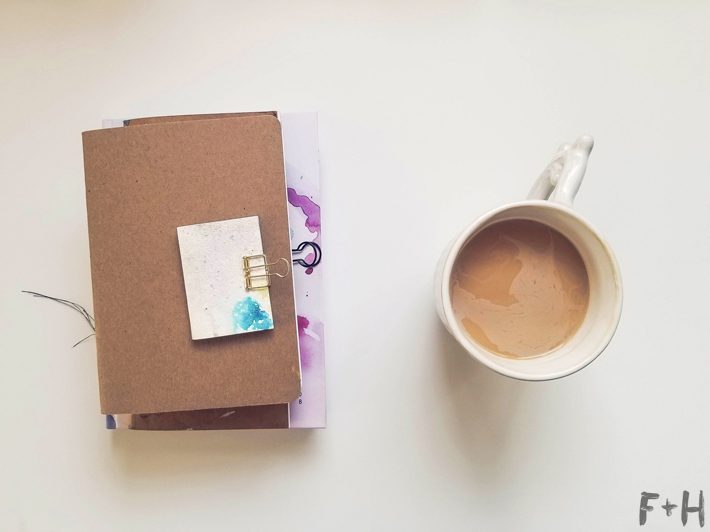 coffee mug and journal on white desk