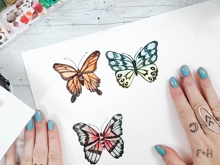 watercolor butterflies on white paper on desk